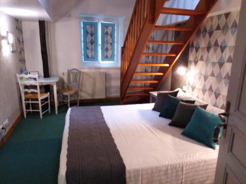 a bedroom with a large bed and a staircase at Hôtel Picardia in Saint-Valery-sur-Somme