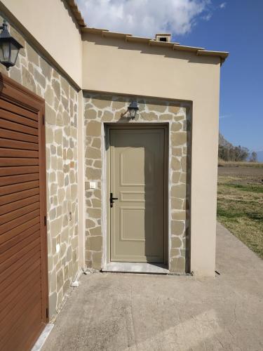 a garage with a door in a stone building at Kryoneri village in Kryonéri