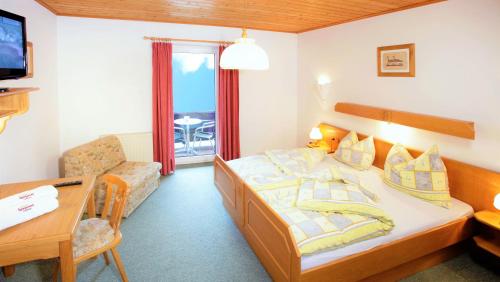 a hotel room with a bed and a desk at Landhotel Haagerhof in Aigen im Mühlkreis