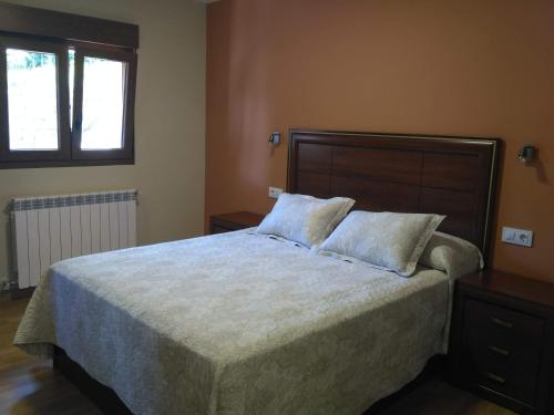 a bedroom with a large bed and a window at APARTAMENTOS CAMINO SANTO TORIBIO in Mieses