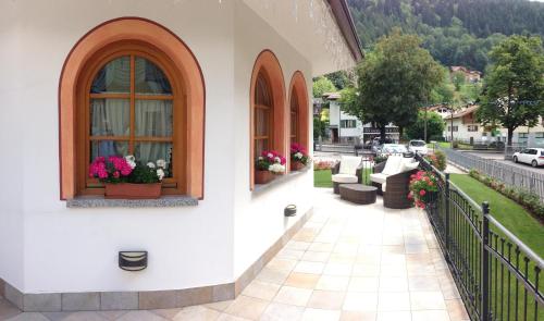 a balcony of a building with flowers in windows at Hotel Cristina in Pinzolo
