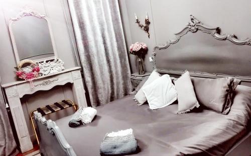 a bedroom with a gray bed with a mirror and a vanity at L'Antico Lido Venice in Venice-Lido