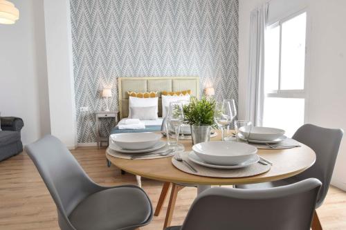 a dining room with a wooden table and chairs at Suite Premium - Cathedral of Malaga in M&aacute;laga