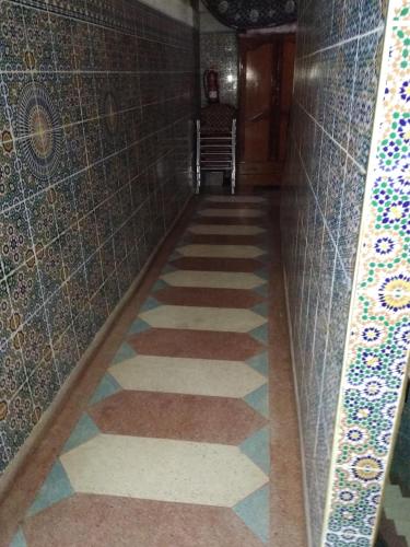 a hallway with tiles on the walls and a floor at Ryad Bab Berdaine in Meknès