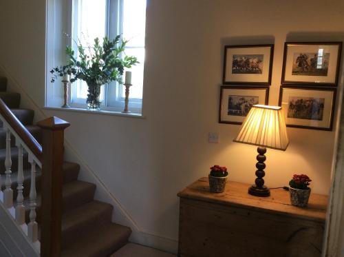 a lamp on a dresser in a hallway with a window at Castle Farm House B&B in Corby