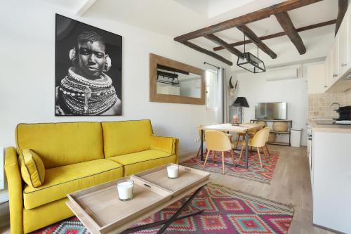 - un salon avec un canapé jaune et une table dans l'établissement Résidence Grands Boulevards by Studio prestige, à Paris