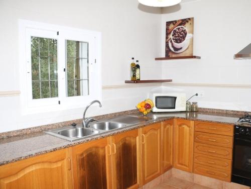 a kitchen with a sink and a microwave at Villa Susan Ibiza in San Antonio