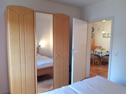 ein Schlafzimmer mit einem Bett und ein Zimmer mit einem Spiegel in der Unterkunft Ferienwohnung 4 im Haus am See mit Wintergarten und Terrasse in Seedorf