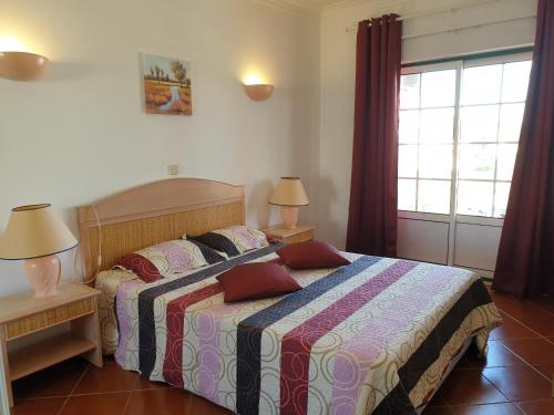 ポルティマンにあるEstrela do Vau Private Apartmentのベッドルーム1室(ベッド1台、ランプ2つ、窓付)