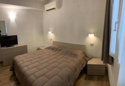 um quarto com uma cama e uma televisão de ecrã plano em Ca du Sergio - Le Mura em Levanto