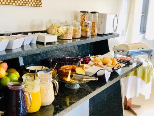 ein Frühstücksbuffet mit Obst und anderen Speisen auf der Theke in der Unterkunft Porto Verde Hotel in Lins