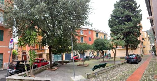 una strada cittadina con auto parcheggiate, alberi ed edifici di Ca du Sergio - Le Mura a Levanto