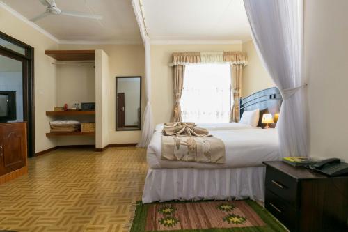 a bedroom with a large bed and a window at Fahari Gardens Hotel in Nairobi