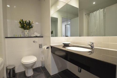 uma casa de banho com um WC, um lavatório e um espelho. em Benbulben Court em Sligo
