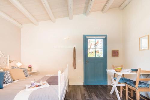 a room with a bed and a table and a door at Locanda Angelica in Giarratana