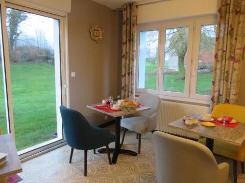 a dining room with a table and chairs and a window at Manoir du Brugnobois in Surques