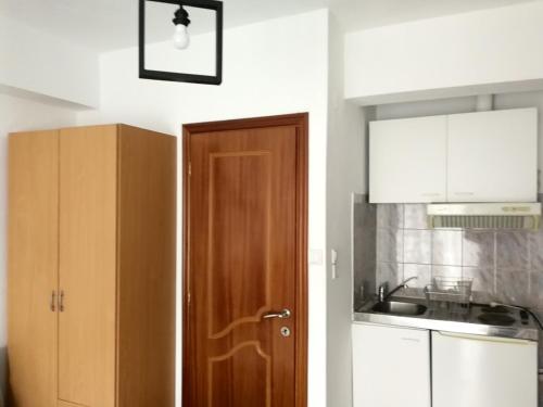 a kitchen with a wooden door and a sink at Iliana's house in Naousa Imathias