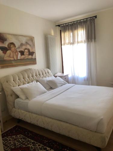 a bedroom with a large white bed with a window at B&B Ca-Casoni in Oderzo