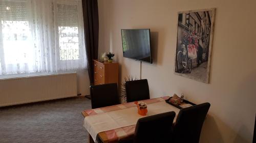 a dining room with a table and a television at ÁRPÁD Apartman in Szekszárd