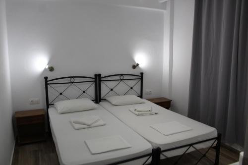 1 dormitorio con 1 cama con 2 almohadas blancas en Zeus Hotel, en Iräon