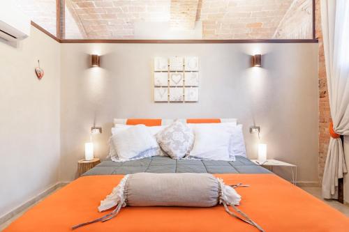 a bedroom with a bed with an orange blanket at Villa Bonelli in Siena