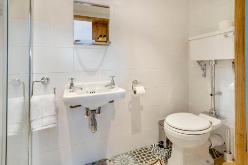 a white bathroom with a toilet and a sink at The Annexe with Hot Tub in Maidstone