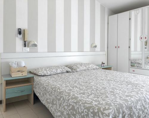 a bedroom with a bed with a striped wall at Alba B&B in Cattolica