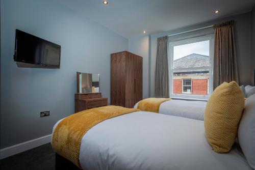 Ліжко або ліжка в номері Gordon Moon Suites Bolton Centre Apartments