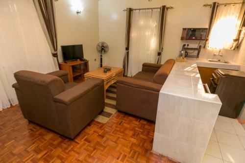 a living room with two couches and a television at Fahari Gardens Hotel in Nairobi