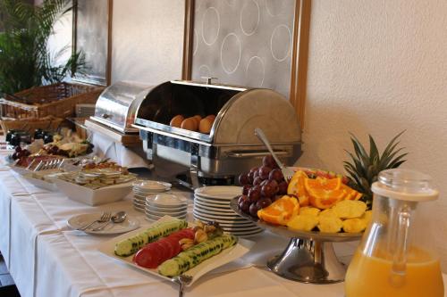 a buffet with fruit and other foods on a table at Hotel Pension Am Hafen in Norddeich