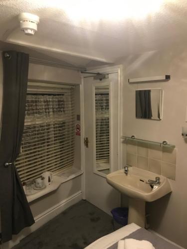 uma casa de banho com um lavatório, um WC e uma janela. em The Unicorn, Ambleside em Ambleside
