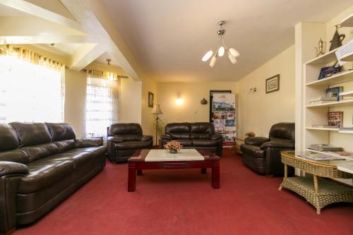 a living room with leather couches and a coffee table at Fahari Gardens Hotel in Nairobi