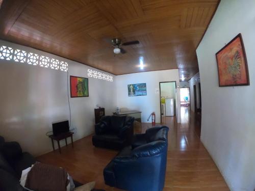 a living room with two chairs and a ceiling at Hostal Augustos in San Juan del Sur