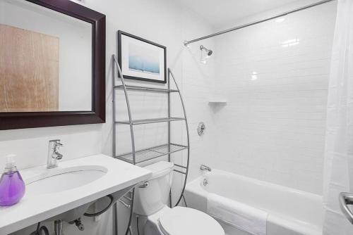 a white bathroom with a toilet and a sink at Temple Place Suites 2+3 in Boston