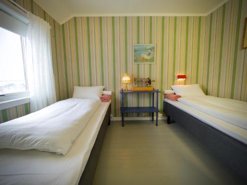 duas camas num quarto com riscas verdes e brancas em Lofoten Bay View em Bøstad