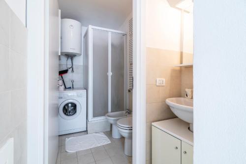ein weißes Badezimmer mit Waschmaschine und Trockner darin in der Unterkunft PrimoPiano - Garofalo A in Mailand