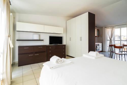 1 Schlafzimmer mit 2 weißen Betten und einem TV in der Unterkunft PrimoPiano - Garofalo A in Mailand