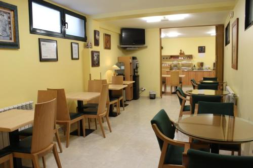 a restaurant with tables and chairs in a room at Hotel Casa Benilde in Palas de Rei