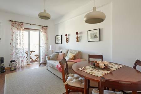 a living room with a table and a couch at Seven Guest House in Falagueira