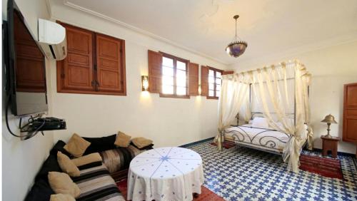 een woonkamer met een bank en een bed bij Dar Abdesalam in Fès