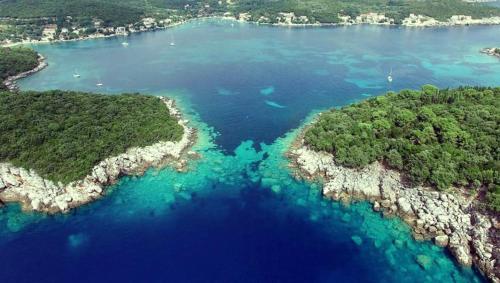 an island in the ocean with turquoise water at Diving Apartments in Molunat