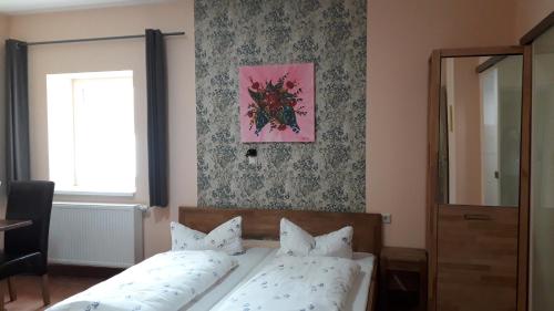 een slaapkamer met een bed en een roze schilderij aan de muur bij Hotel Wittenberg-Hotel Garni in Lutherstadt Wittenberg