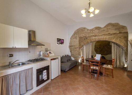eine Küche und ein Wohnzimmer mit einem Tisch und einem Sofa in der Unterkunft Camere La Basilica in Assisi