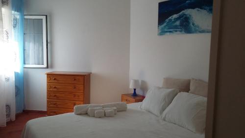 a bedroom with a bed with white sheets and a dresser at Cantinho Das Estrelas, Luz Lagos in Luz