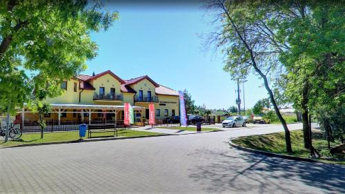 una calle con un edificio al lado de una carretera en Posejdon, en Grzybowo