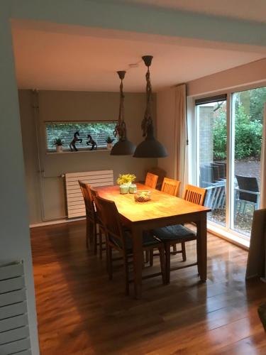 a dining room with a wooden table and chairs at Vakantiewoning Tjiftjaf in "Het Fonteinbos" in Oudemirdum