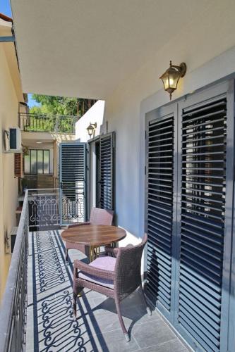 a patio with a wooden table and chairs on a balcony at Anja in Kotor