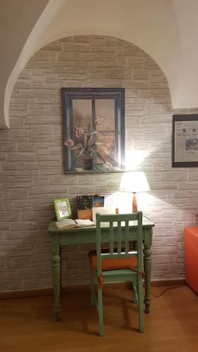 un escritorio verde con una silla y una lámpara en B&B Dei Doria, en Dolceacqua