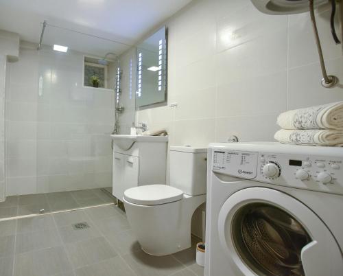 a bathroom with a toilet and a washing machine at Palm square 1 Old town apt in Budva