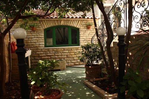 a house with a green window and some plants at Hostel Splendido in Šibenik